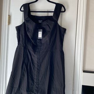 Black sleeveless linen dress with hook and eye closure down front of dress.